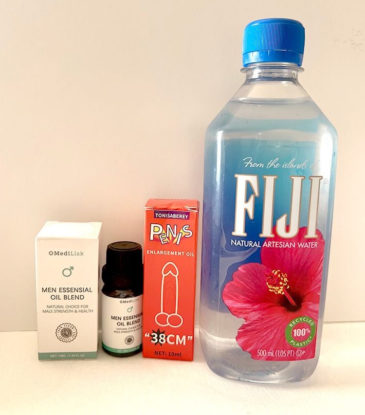 Men Essensial Oil Blend bottle next to Fiji water bottle